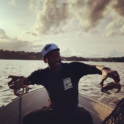 He is holding a crab on his both hands.